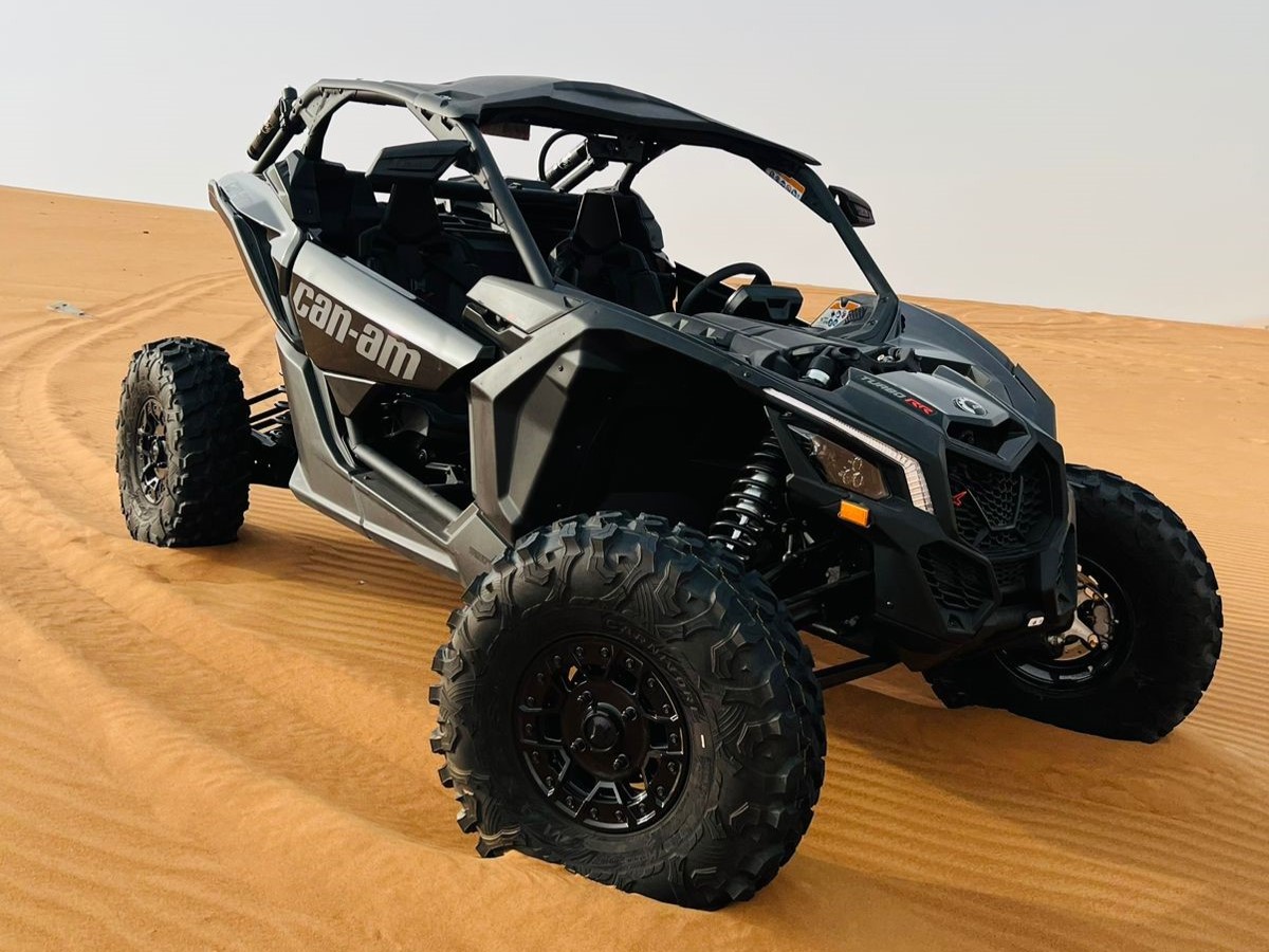 Buggy CanAm Maverick Turbo noir dans le sable du désert de Dubaï , prêt à partir en tour avec ses 2 passagers