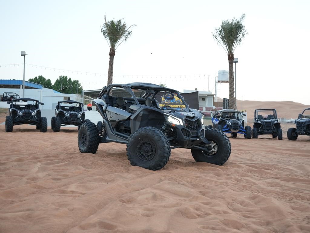 Buggy CanAm Maverick Turbo noir dans le sable du désert de Dubaï , prêt à partir en tour avec ses 2 passagers