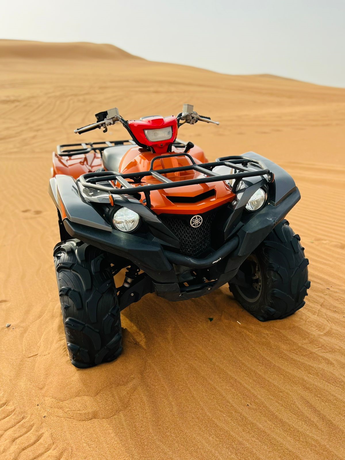 Yamaha Grizzly Rouge dans le sable du désert de Dubaï , prêt à partir en tour